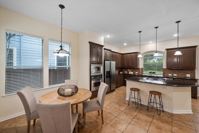 kitchen featuring decorative backsplash, pendant lighting, and stainless steel appliances