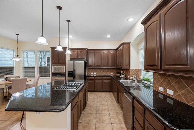 kitchen featuring a center island, sink, hanging light fixtures, dark brown cabinets, and stainless steel appliances