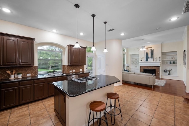 kitchen with a breakfast bar, a center island, light tile patterned floors, and backsplash