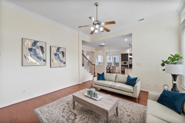 living room with hardwood / wood-style flooring, ceiling fan, and crown molding