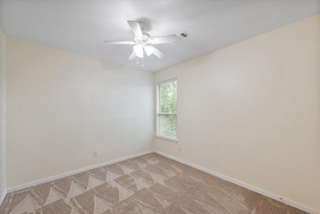 empty room with ceiling fan and light carpet