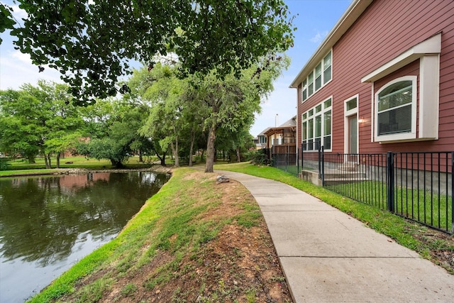 view of home's community with a water view and a yard