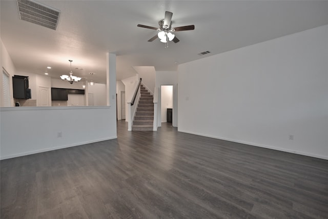 unfurnished living room featuring ceiling fan with notable chandelier and dark hardwood / wood-style floors