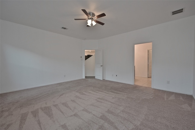 spare room featuring light colored carpet and ceiling fan