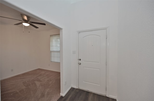 entrance foyer with ceiling fan and dark carpet