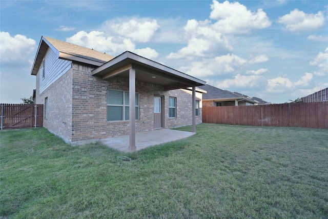 rear view of house featuring a patio area and a yard