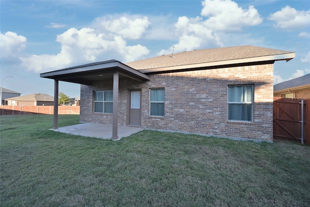 back of property featuring a lawn and a patio