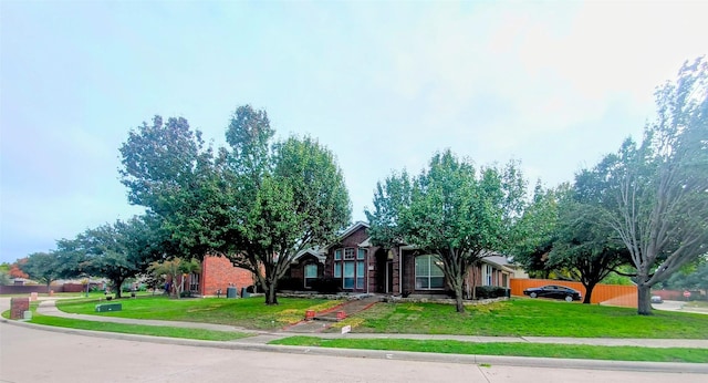 340 Thomas Dr, Murphy, TX 75094 - view of property hidden behind natural elements with a front yard and brick siding