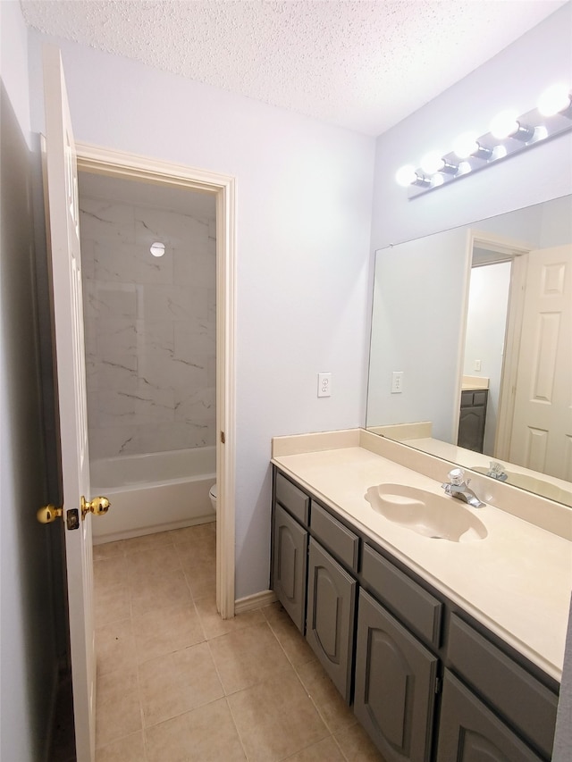 bathroom featuring tile patterned floors, vanity, toilet, and a textured ceiling