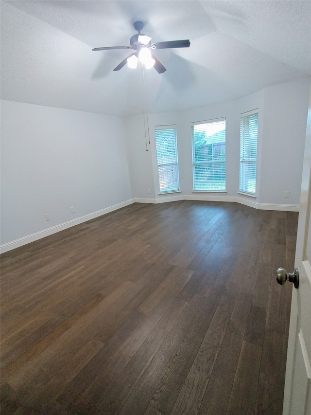 spare room with ceiling fan, dark hardwood / wood-style flooring, and vaulted ceiling