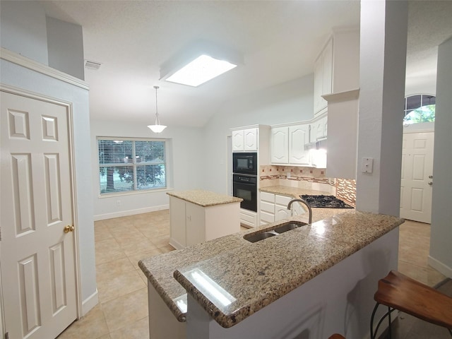 340 Thomas Dr, Murphy, TX 75094 - kitchen featuring black appliances, light stone countertops, a peninsula, lofted ceiling, and a kitchen island