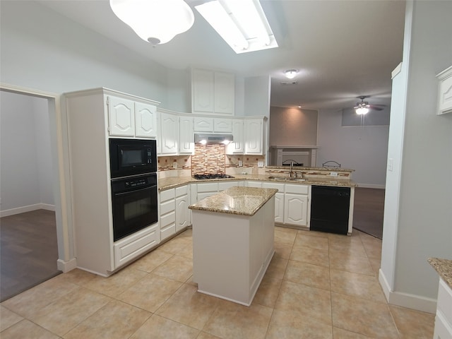 kitchen with black appliances, kitchen peninsula, a kitchen island, light stone counters, and white cabinetry