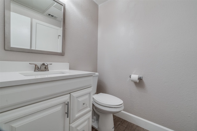 bathroom with hardwood / wood-style flooring, vanity, and toilet