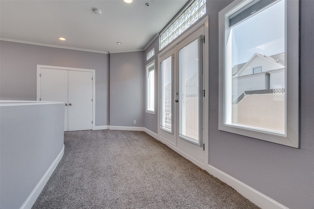 unfurnished room featuring crown molding and carpet