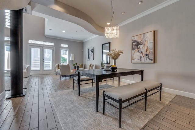 dining area featuring crown molding, french doors, light hardwood / wood-style floors, and a notable chandelier