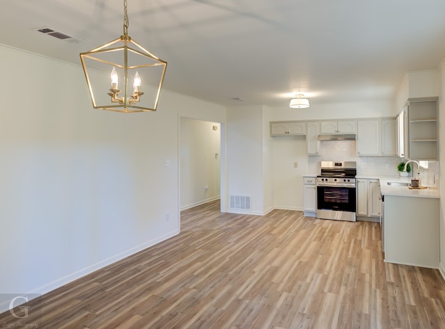 kitchen with crown molding, light hardwood / wood-style flooring, stainless steel stove, and hanging light fixtures