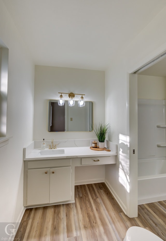 full bathroom with hardwood / wood-style floors, vanity, toilet, and shower / bathing tub combination