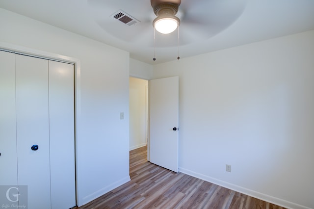 unfurnished bedroom featuring ceiling fan, a closet, and light hardwood / wood-style floors