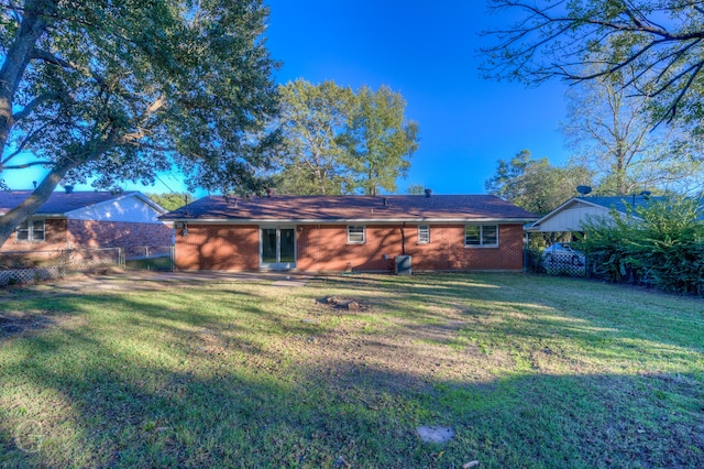 rear view of house featuring a lawn