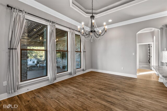 unfurnished dining area featuring hardwood / wood-style flooring, an inviting chandelier, and ornamental molding