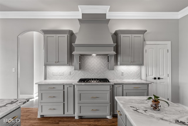 kitchen with light stone countertops, dark hardwood / wood-style floors, stainless steel gas stovetop, and gray cabinetry