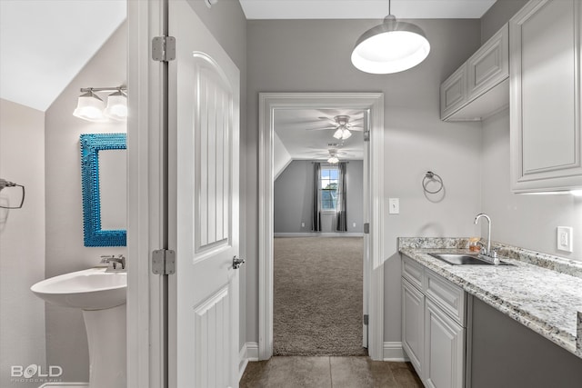 bathroom featuring vaulted ceiling, ceiling fan, and sink