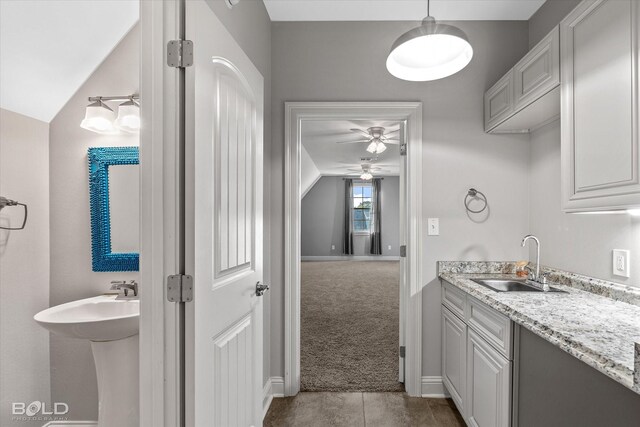 bathroom featuring vaulted ceiling, ceiling fan, and sink