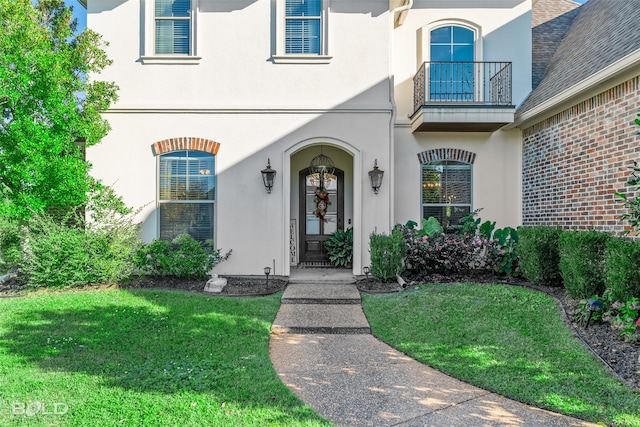 view of exterior entry featuring a lawn