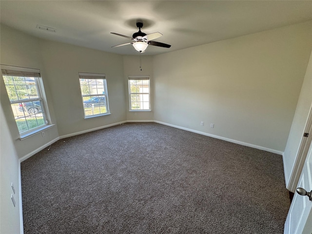 unfurnished room featuring dark colored carpet and ceiling fan