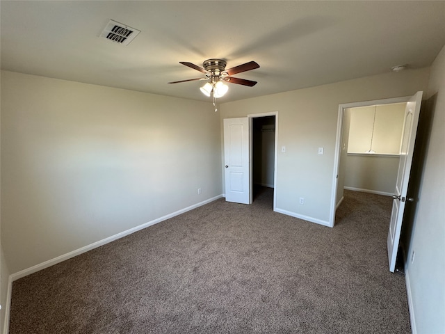 unfurnished bedroom featuring ceiling fan, a closet, and dark carpet