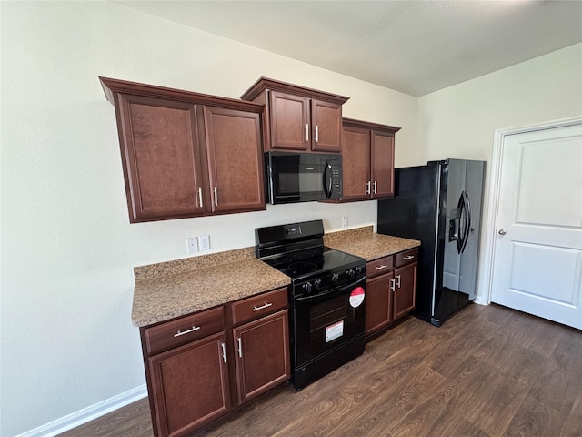 kitchen with black appliances and dark hardwood / wood-style floors