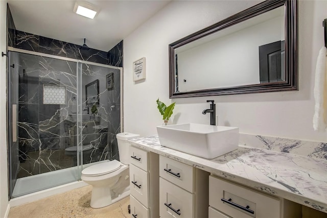 bathroom with vanity, toilet, and a shower with door