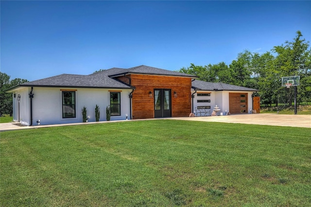 view of front of property with a garage, a front yard, and french doors