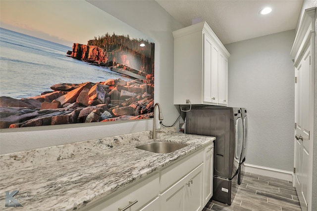 laundry area with cabinets, sink, and washing machine and dryer