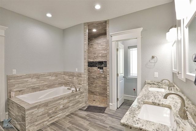 bathroom with vanity and tiled tub