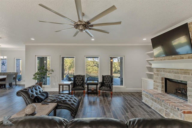 living room featuring crown molding, a textured ceiling, built in features, hardwood / wood-style flooring, and a fireplace