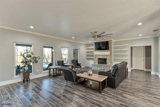 living room featuring dark hardwood / wood-style flooring, built in shelves, a stone fireplace, and a textured ceiling