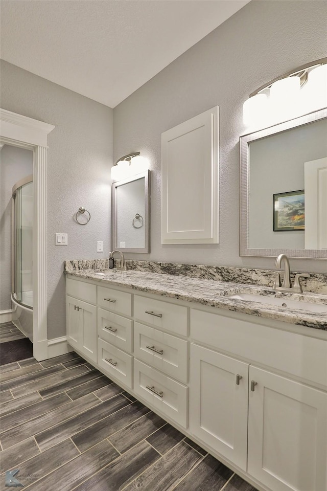 bathroom featuring vanity and a shower with door