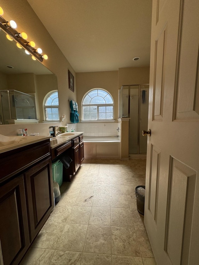 bathroom featuring tile patterned flooring, vanity, and separate shower and tub