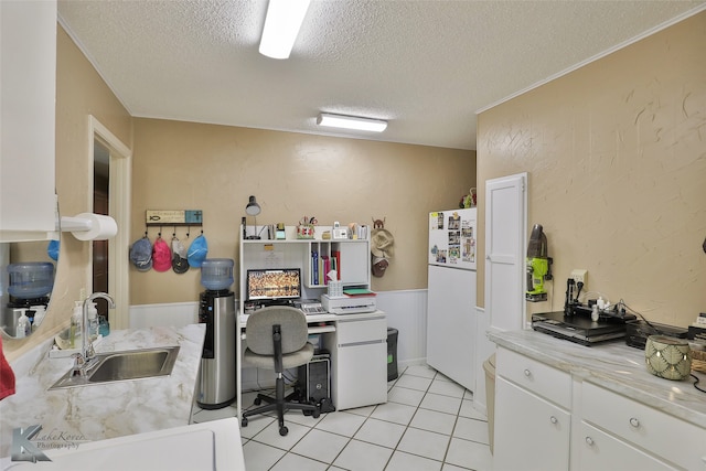 office area with light tile patterned floors, a textured ceiling, and sink