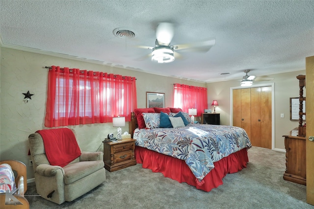 carpeted bedroom featuring ceiling fan, a closet, a textured ceiling, and ornamental molding