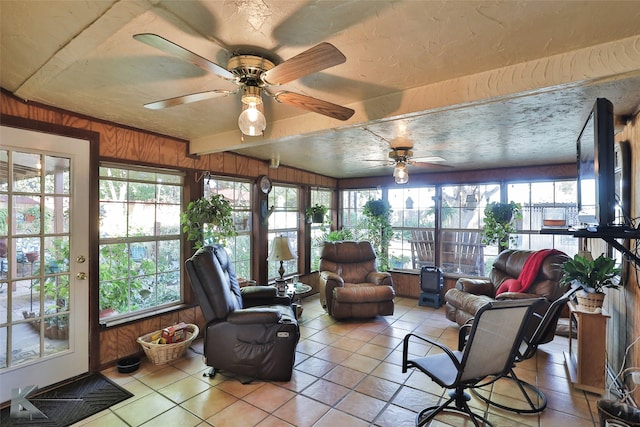 sunroom featuring vaulted ceiling with beams, a wealth of natural light, and ceiling fan