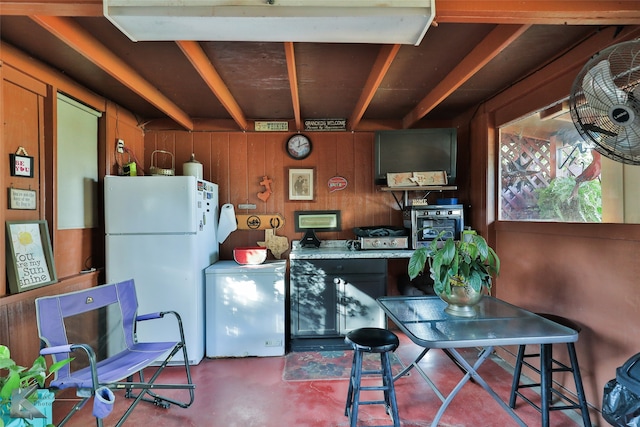 kitchen with a breakfast bar, white refrigerator, refrigerator, and wooden walls