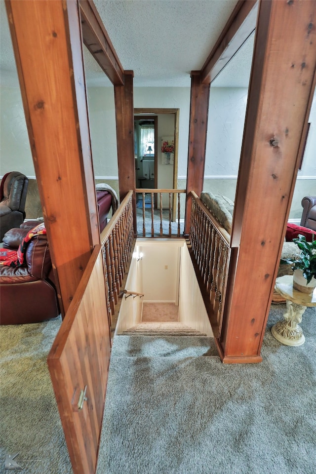 hallway with carpet and a textured ceiling