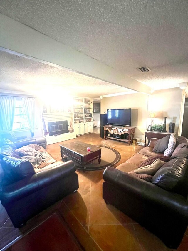 tiled living room featuring a textured ceiling