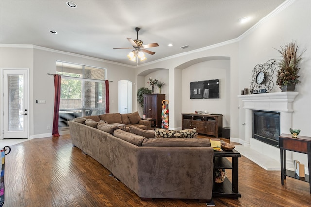 804 Colby Dr, Mansfield, TX 76063 - living room with arched walkways, a glass covered fireplace, a ceiling fan, dark wood-type flooring, and crown molding