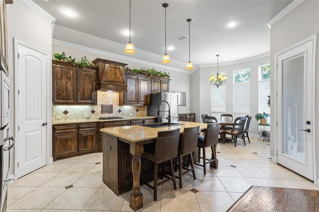 804 Colby Dr, Mansfield, TX 76063 - kitchen with freestanding refrigerator, custom exhaust hood, ornamental molding, tasteful backsplash, and a center island with sink