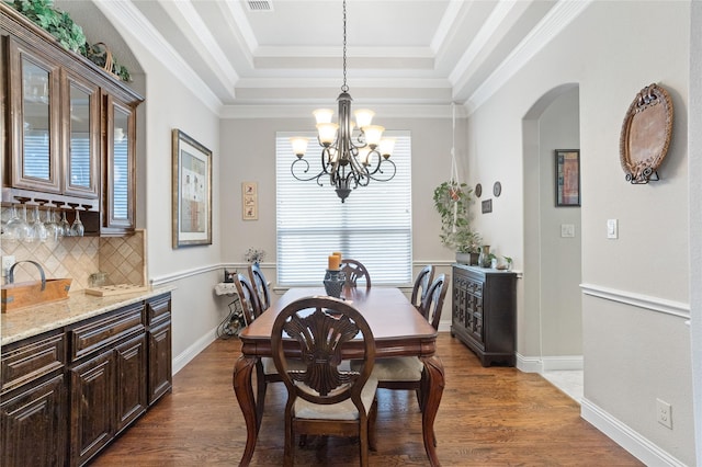 804 Colby Dr, Mansfield, TX 76063 - dining space with arched walkways, a raised ceiling, a chandelier, and wood finished floors