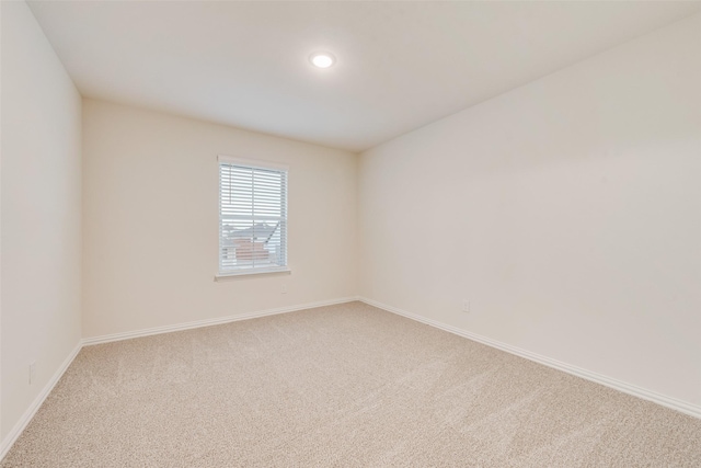 carpeted spare room featuring baseboards