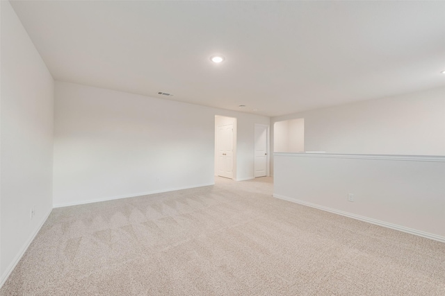 unfurnished room featuring recessed lighting, light carpet, visible vents, and baseboards